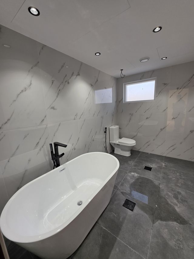 Grey marble-look bathroom with a freestanding bath