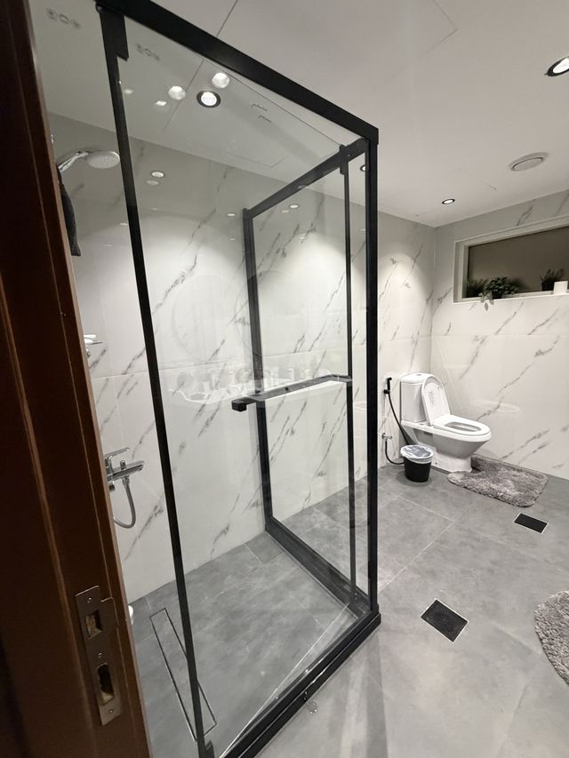 White marble-look bathroom with a black-framed shower