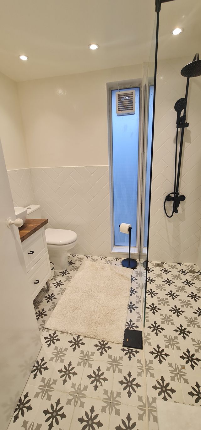 Bathroom with patterned tiles and black fittings